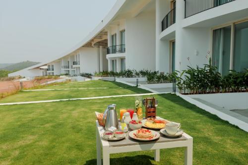 a table with food and drinks on top of a lawn at Araqila Boutique Beach Resort near MOPA airport in Vengurla