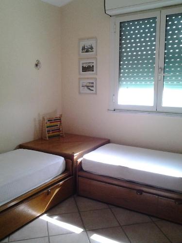 two beds sitting in a room with a window at Appartamento Arenella in Arenella