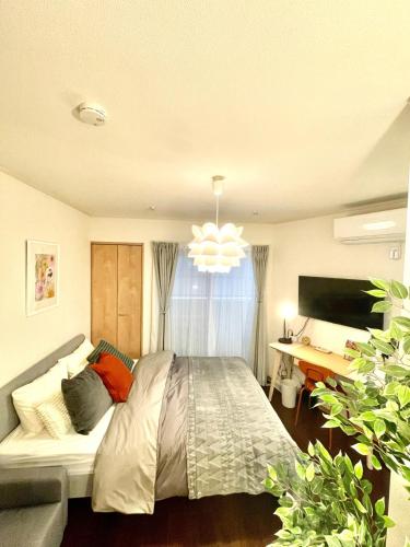 a bedroom with a large bed and a desk at Oasis Stay Tokyo in Soka