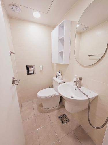 a bathroom with a sink and a toilet and a mirror at New 패밀리 & 친구 여행 모임 청결하고 쾌적한 넓은 신축아파트 주차 편리 쓰리룸 in Bucheon