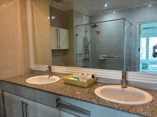 a bathroom with two sinks and a large mirror at View Talay 6 Pattaya Beach by Anatolia Condo Suite in Pattaya