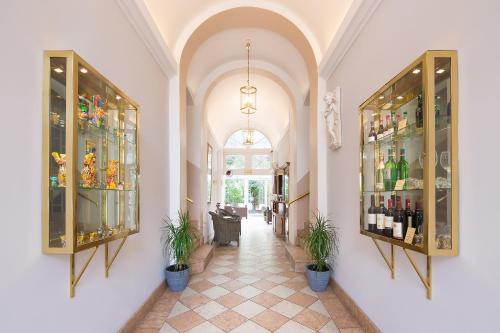 a hallway with shelves of wine bottles and plants at Gold Hotel in Berlin