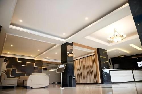 a lobby with a chandelier on the ceiling at Karlita Hotel Tegal in Tegal
