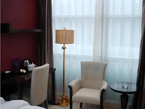 a room with a table and two chairs and a lamp at Milu Hotel in Guangzhou