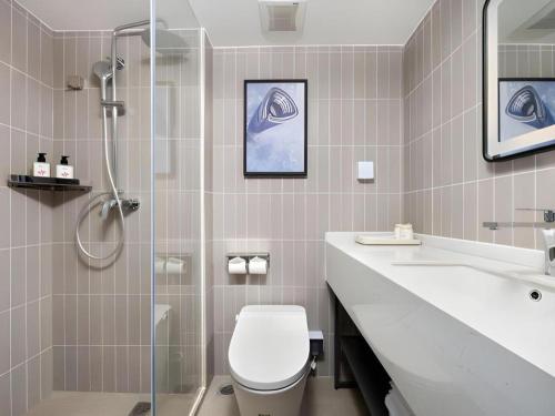 a bathroom with a shower and a toilet and a sink at Jinjiang Inn Shenzhen Airport in Shenzhen