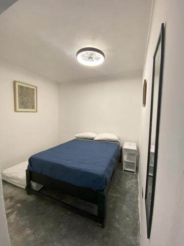 a bedroom with a bed with a blue blanket at DGM Lofts GPE 7 cerca estadio Rayados MTY in Monterrey