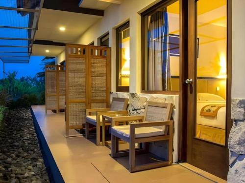 a patio with chairs and a table and a door at Sambi Resort, Spa & Resto in Yogyakarta