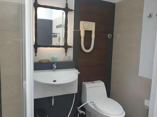 KampungdurianにあるSavali Hotelのトイレ、洗面台、鏡のあるバスルーム