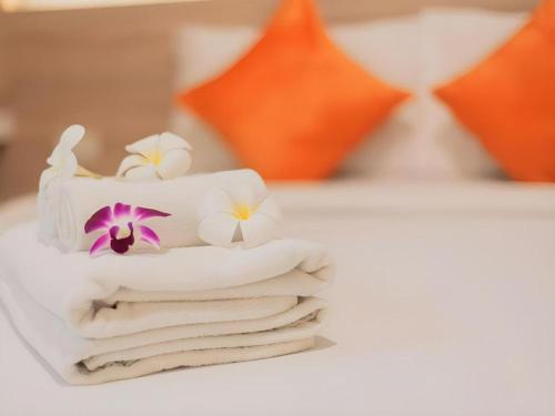 a white cake with flowers on top of towels at B2 Khamtieng Boutique & Budget Hotel in Chiang Mai