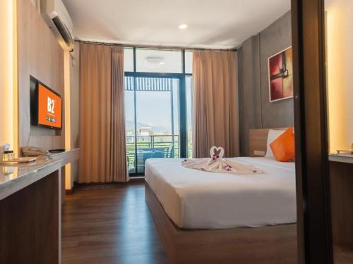 a hotel room with a bed and a balcony at B2 Khamtieng Boutique & Budget Hotel in Chiang Mai
