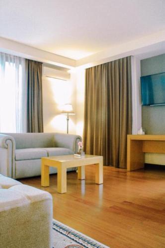 a living room with a couch and a coffee table at The Axana Hotel in Padang