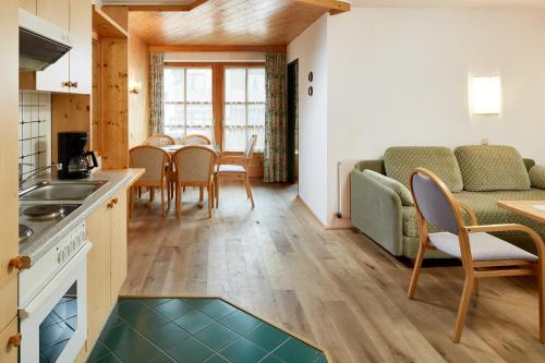 a kitchen and living room with a couch and a table at Sporthotel Kogler in Mittersill
