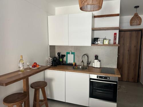 a kitchen with white cabinets and a sink at VMJ side sea view in Perea