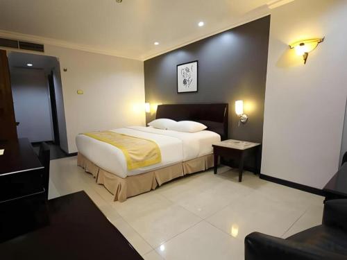 a hotel room with a bed and a couch at Hotel Banjarmasin International in Benuaanyar