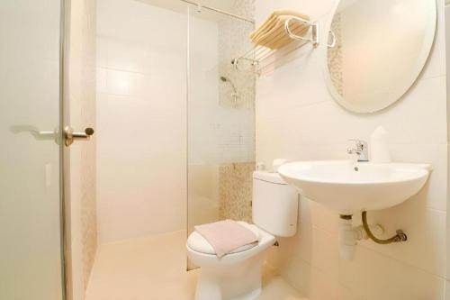 a bathroom with a sink and a toilet and a mirror at Lovina Inn Hotel Batam in Nagoya