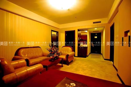 a living room with a couch and two chairs at Yanji Yanbian International Hotel in Yanji
