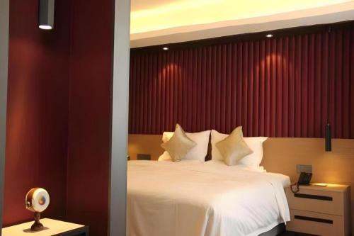 a bedroom with a white bed with a red wall at Yanji Yanbian International Hotel in Yanji