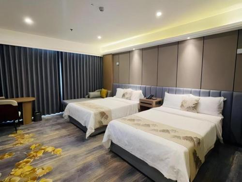a hotel room with two beds and a desk at Yanji Yanbian International Hotel in Yanji