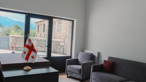 a room with a table and two chairs and a window at Shushabandi Kazbegi in Stepantsminda