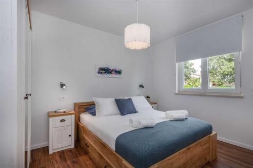 a bedroom with a bed with a blue blanket at Villa Grace, a romantic single story villa with a pool in VeliGolji