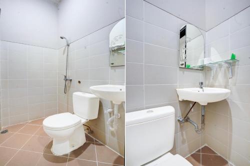 a white bathroom with a toilet and a sink at Townhouse Oak Padang near RTH Imam Bonjol formerly Bunda Hotel in Padang