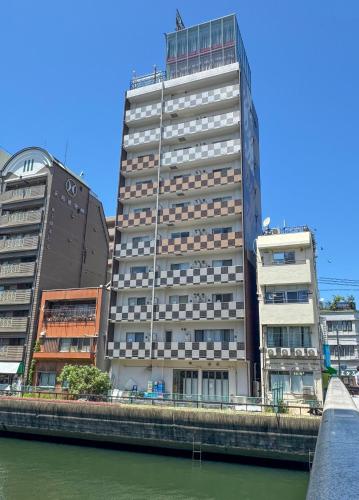a tall building next to a river with buildings at Dotonbori Royal II in Osaka