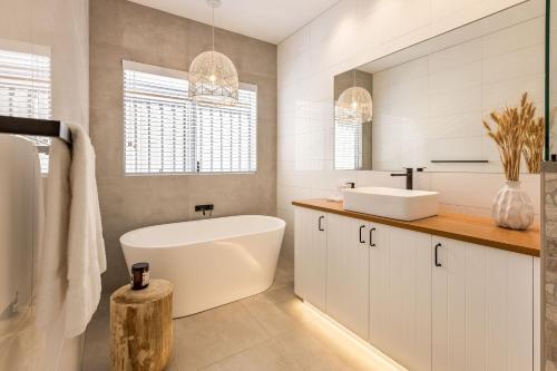 a white bathroom with a tub and a sink at LJ's Hideout in Dunsborough