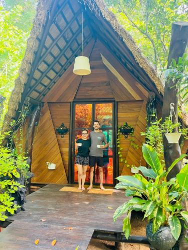 two people standing in the doorway of a tree house at Chika's Place River View Udawalawa in Udawalawe