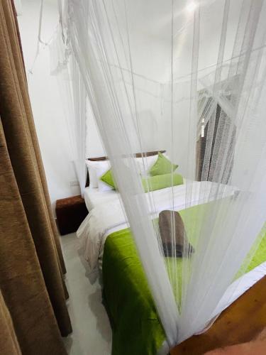 a bedroom with a green bed with a mosquito net at Ella Hillcrest Heaven-Free Pickup from Ella in Ella