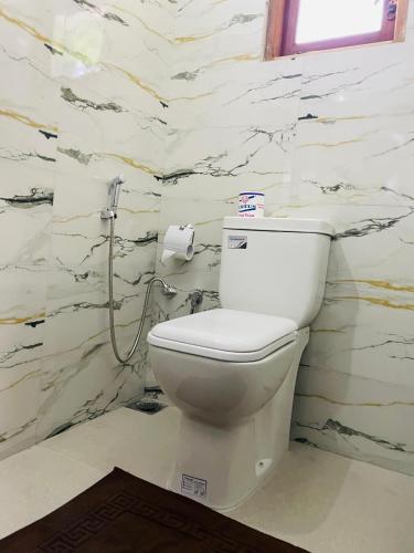 a white toilet in a bathroom with marble walls at Ella Hillcrest Heaven-Free Pickup from Ella in Ella