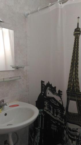 ein Badezimmer mit Waschbecken und dem Eiffelturm an der Wand in der Unterkunft Studio Nera in Pomorie