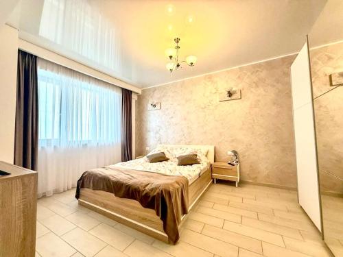 a bedroom with a bed and a large window at Apartament 2 camere Mamaia Nord in Mamaia Nord
