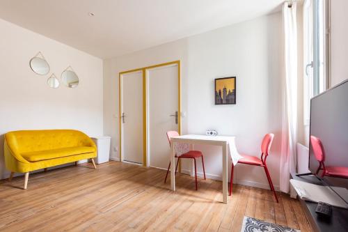 un salon avec un canapé jaune et une table dans l'établissement T1 Bis Cosy proche Gare, à Lourdes