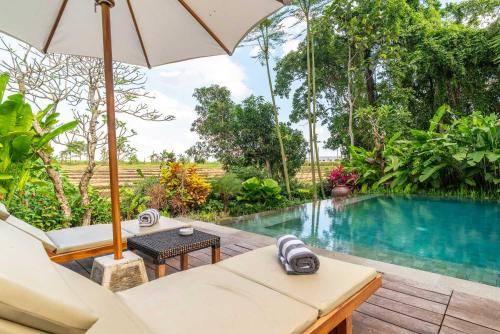 una villa con piscina y sombrilla en 3 BR Barani Villa Tanah Lot with Rice Paddy View & Private Pool, en Tanah Lot