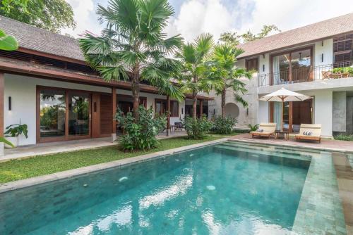 una imagen de una piscina frente a una casa en 3 BR Barani Villa Tanah Lot with Rice Paddy View & Private Pool, en Tanah Lot