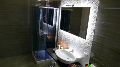 a bathroom with a sink and a shower and a mirror at Cairoli Exclusive Rooms & Suite in Brindisi