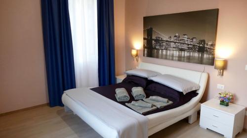 ein Schlafzimmer mit einem Bett mit zwei Kissen und einem Gemälde in der Unterkunft Cairoli Exclusive Rooms & Suite in Brindisi