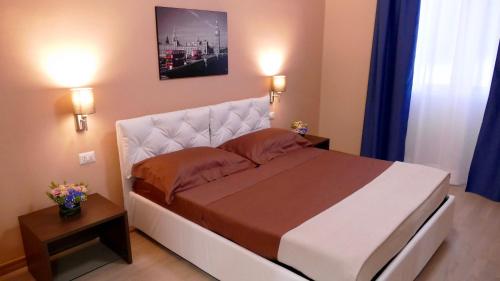a bedroom with a large bed with two lights on at Cairoli Exclusive Rooms & Suite in Brindisi