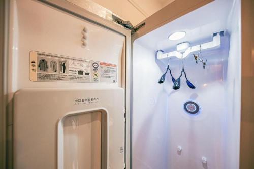 a refrigerator with a mirror and some utensils at Cheongju Maryjane Hotel in Cheongju