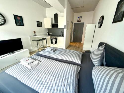 a bedroom with two beds and a living room at NEU MotoLoft Schwarzwaldhochstraße Zentrum Goldstadt Pforzheim Schlössle in Pforzheim