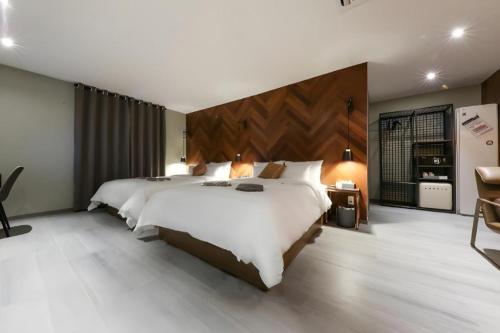 a large bedroom with a large white bed and a desk at Cheongju Maryjane Hotel in Cheongju
