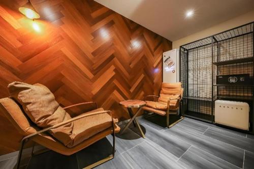 a barber shop with two chairs in a room with wooden walls at Cheongju Maryjane Hotel in Cheongju