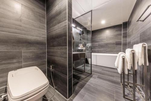 a bathroom with a white toilet and a shower at Cheongju Maryjane Hotel in Cheongju