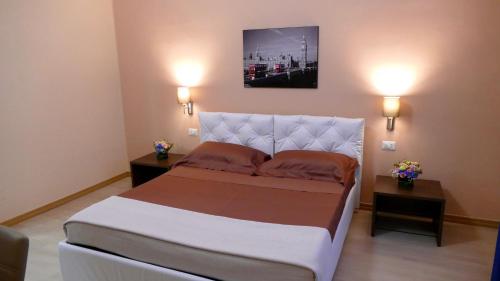 a bedroom with a large bed with two night stands at Cairoli Exclusive Rooms & Suite in Brindisi