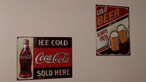 two old coca cola signs hanging on a wall at Cairoli Exclusive Rooms & Suite in Brindisi