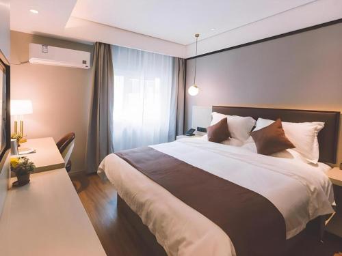 Postel nebo postele na pokoji v ubytování GYA Shanghai Jiangpu Hotel