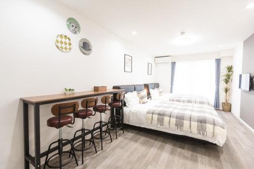 a white bedroom with a bed and stools at b&岸里店 in Osaka