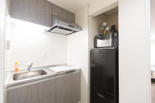 a kitchen with a sink and a refrigerator at b&岸里店 in Osaka