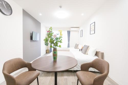 a white living room with a table and chairs at b&岸里店 in Osaka