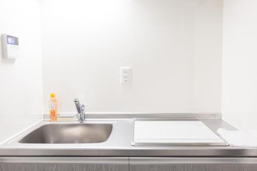 a stainless steel kitchen sink with a paper on it at b&岸里店 in Osaka